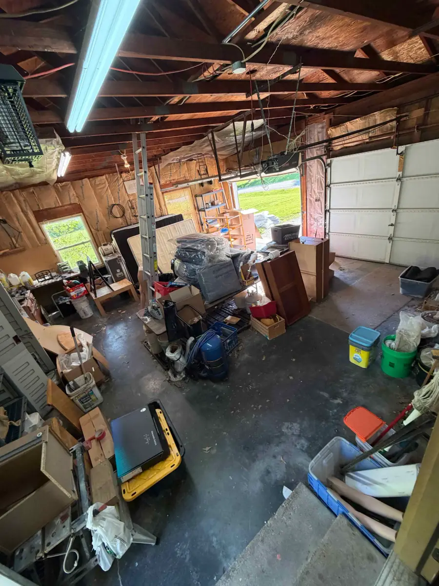 Garage in Peoria IL packed with old furniture and accumulated junk before cleanout