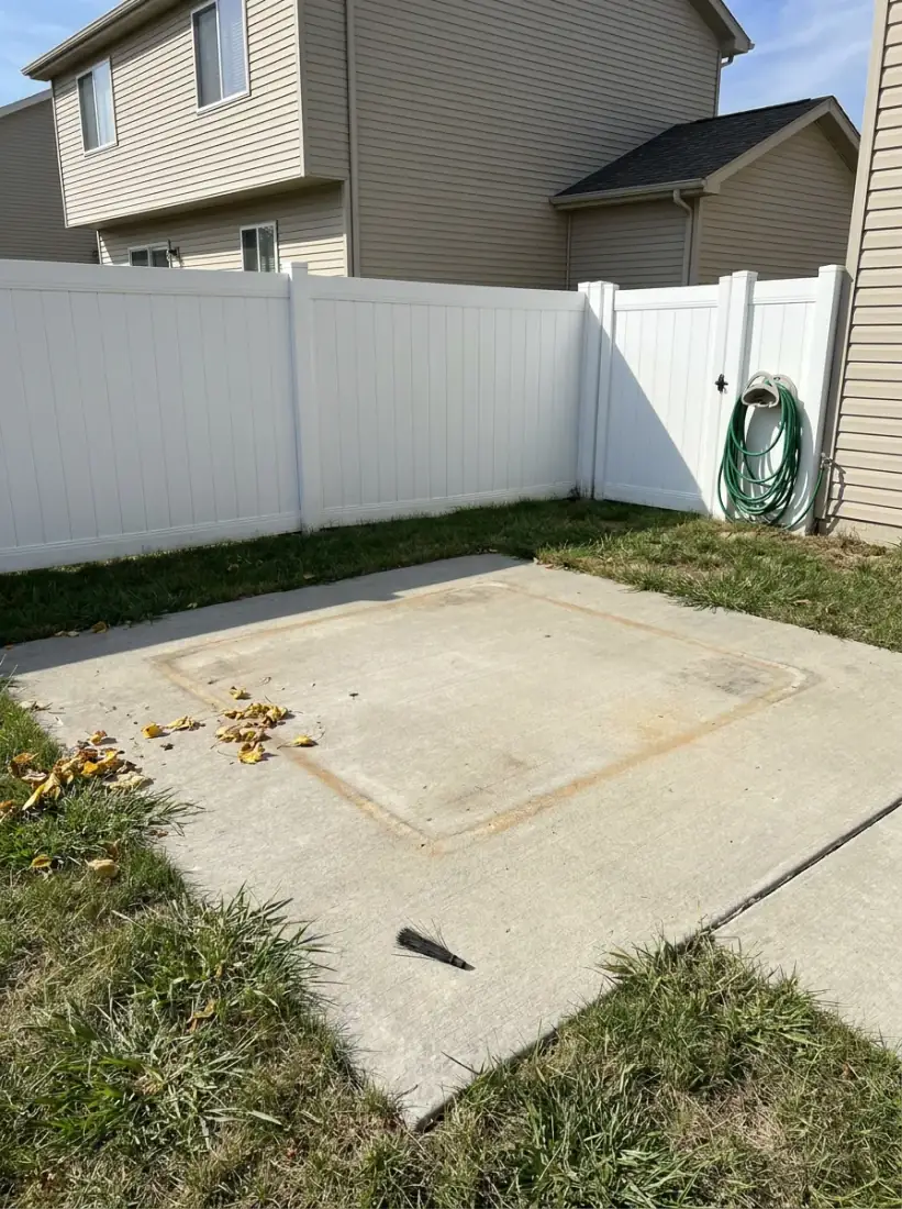 Same Dunlap IL backyard with hot tub dismantled and hauled away, clean concrete pad remaining
